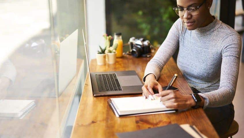 person making notes while working in office