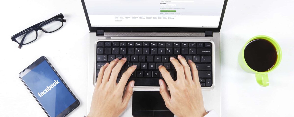 a businessman logging onto Facebook on his laptop