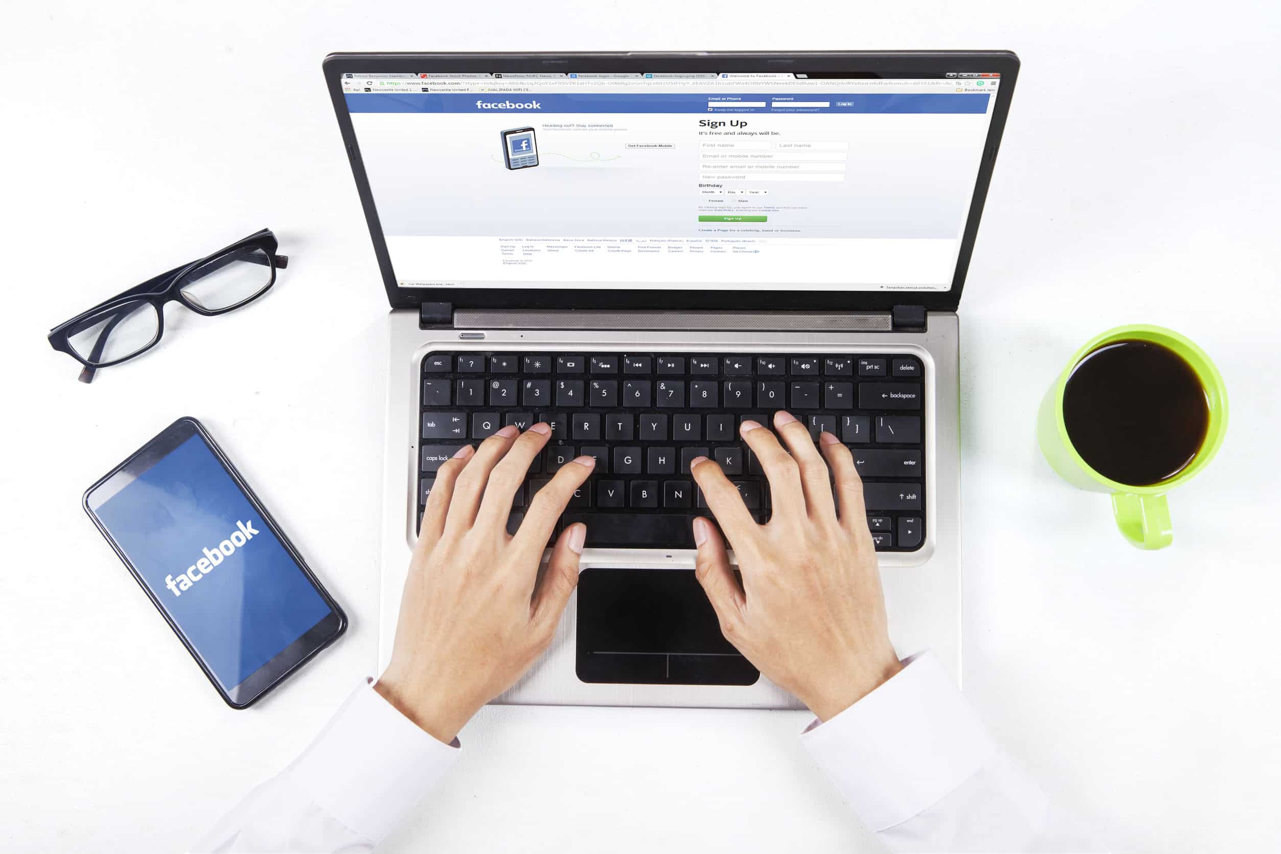 a businessman logging onto Facebook on his laptop