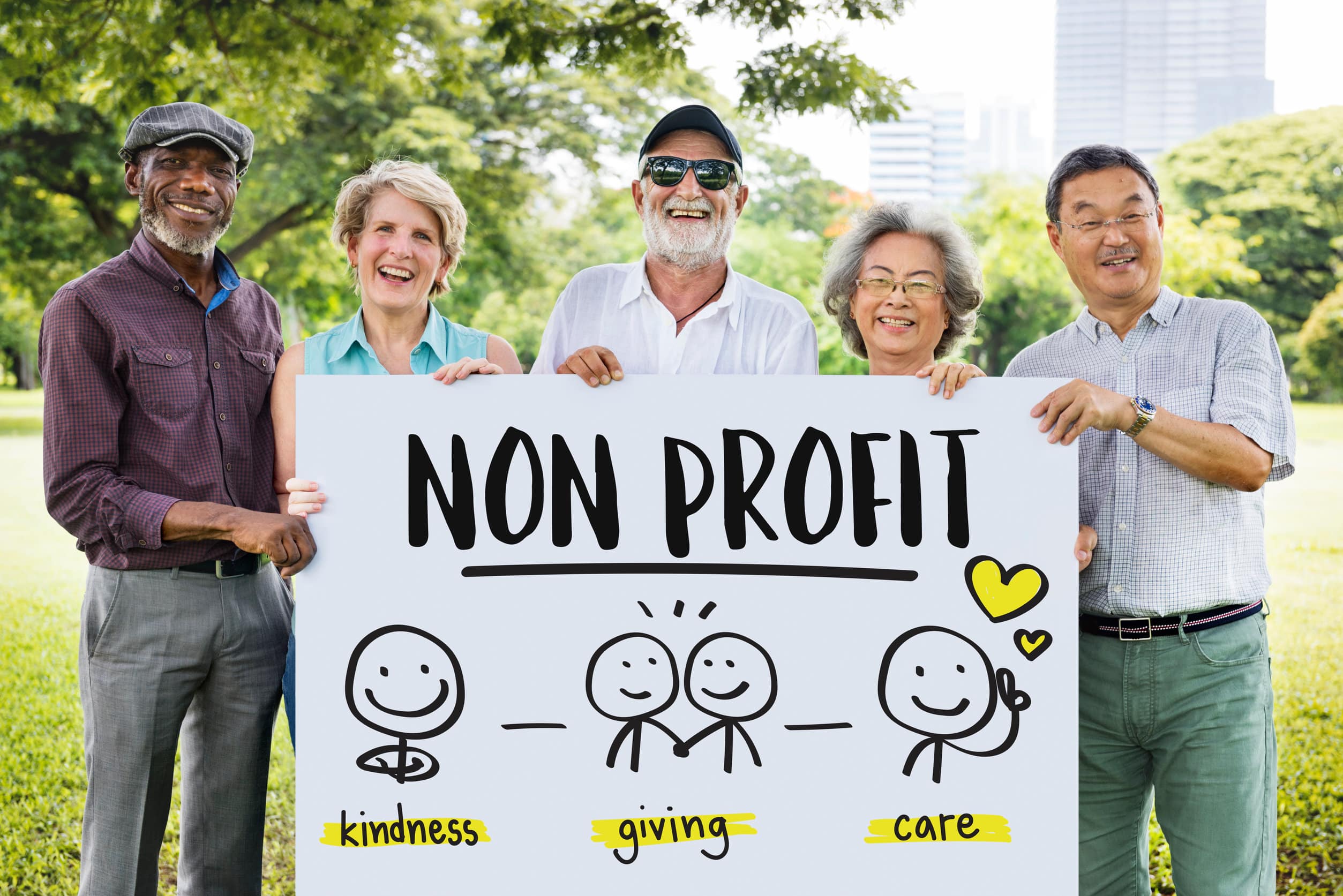 five nonprofit volunteers holding a sign in a park