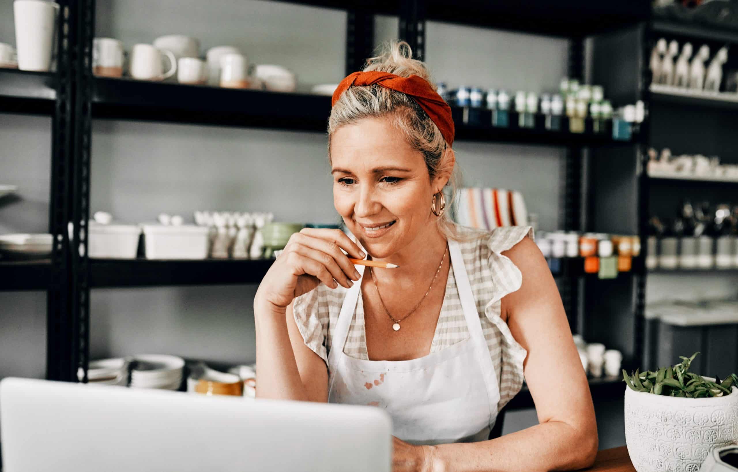 woman sitting alone and using her laptop in her workshop