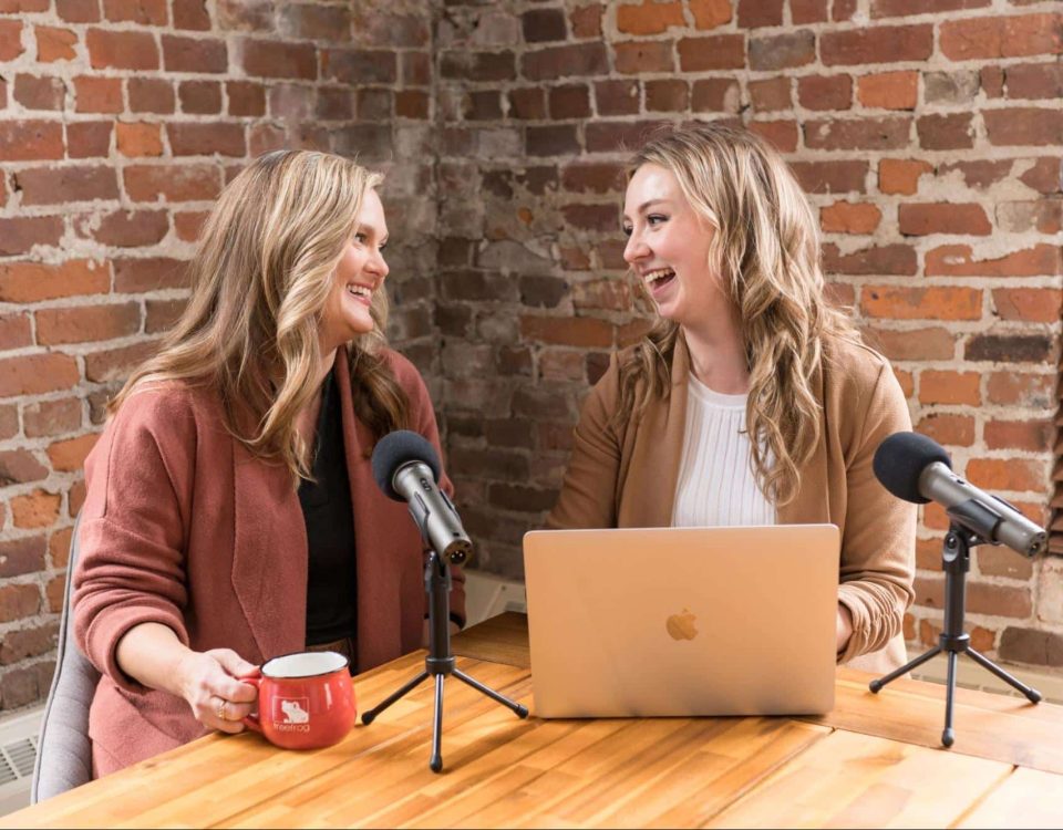 Kelly and Victoria laughing during a podcast.